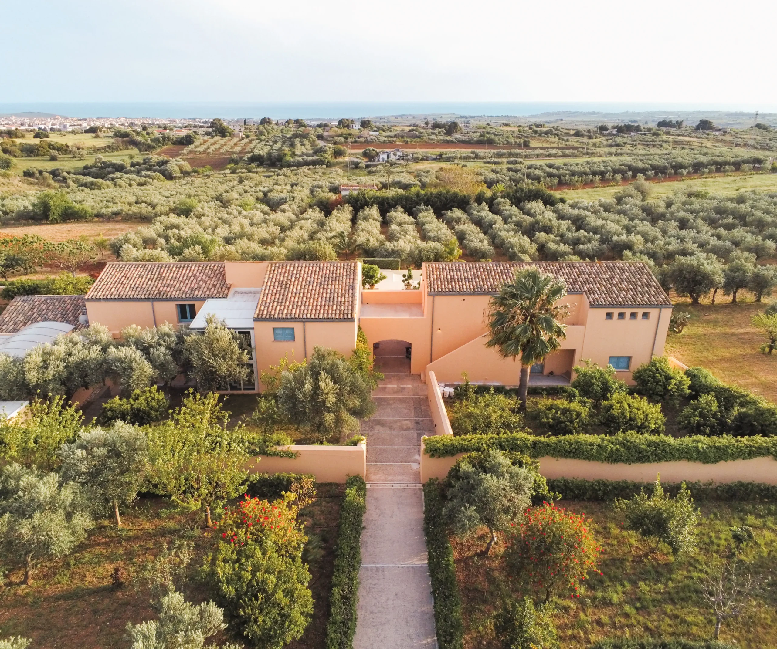 The luxurious La Segreta Country House in Sicily, where Alexandra Meffert hosts an exclusive stress management retreat, offering breathtaking ocean views and traditional Italian architecture in collaboration with the Planeta Family.