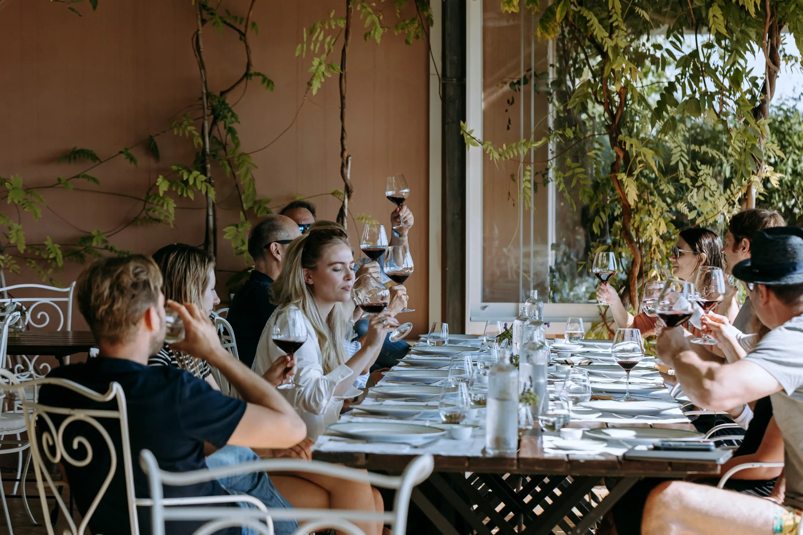 spring 2023 luxury yoga retreat wine tasting. beautiful People sitting and having lunch with a glass red wine