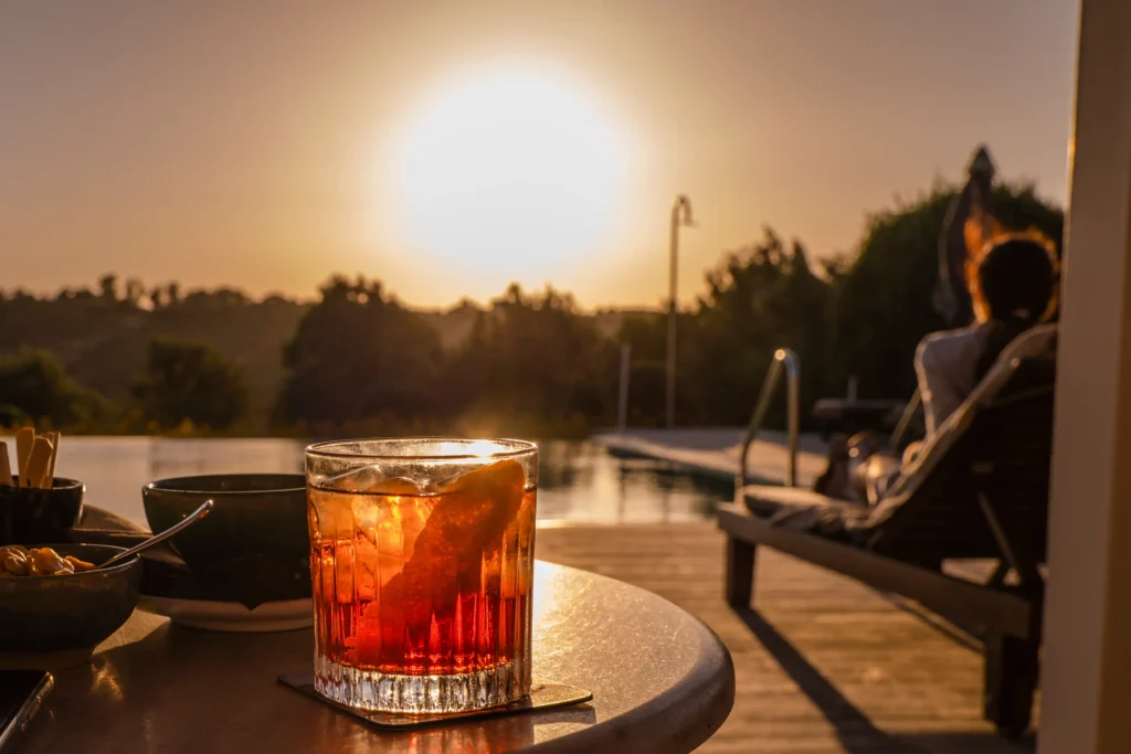 Sicily luxury yoga retreat aperitivo: a glass with campary in the sundown at the pool at la foresteria for the enjoyment in the evening for the sicily luxury retreat