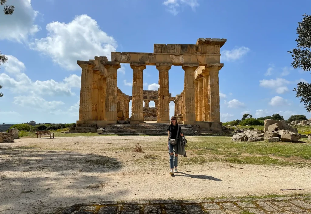 Sicily luxury yoga retreats cultural and art events. Alex meffert in front of the columns of temple C in Selinunte archeological park in a sunny day